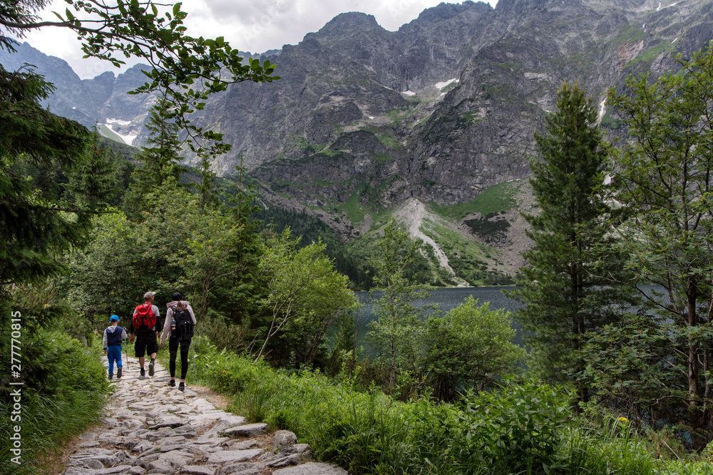 Young family exploring road in the mountain. Tatra National Park, Poland.