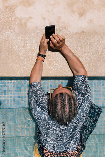 Man using smartphone in swimming pool photo