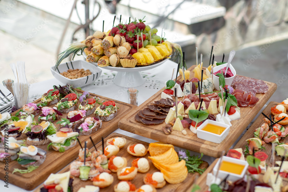 Ταπετσαρία Large selection of food with cold snacks, meat and salads, fruit, cold meats, cheese and jam served