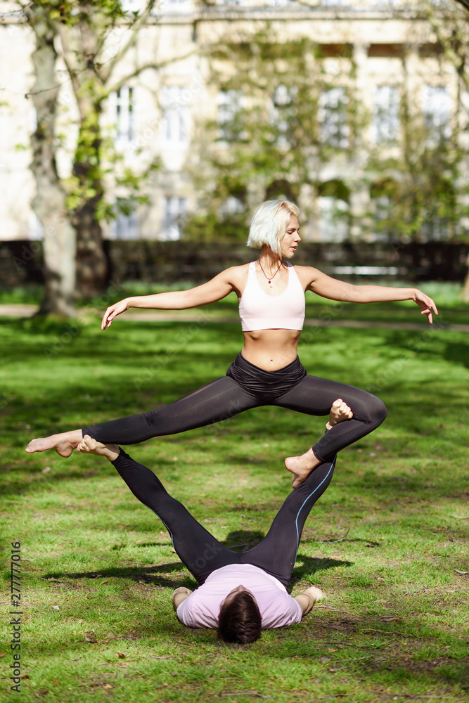 Young couple doing yoga acrobatics in an urban park Young couple doing yoga acrobatics in an urban park