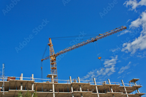 construction crane and building under construction against blue sky