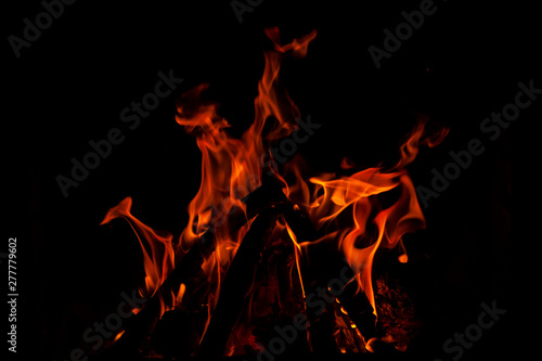 Fundo escuro com chamas de fogo de lareira formando figuras abastratas.
