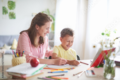 Fotografie mother helps son to do lessons