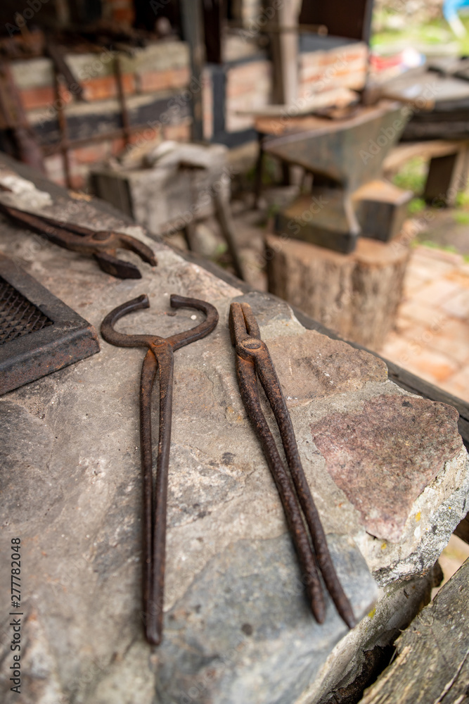 Tools in an old blacksmith's workshop. Pliers for holding hot metal.