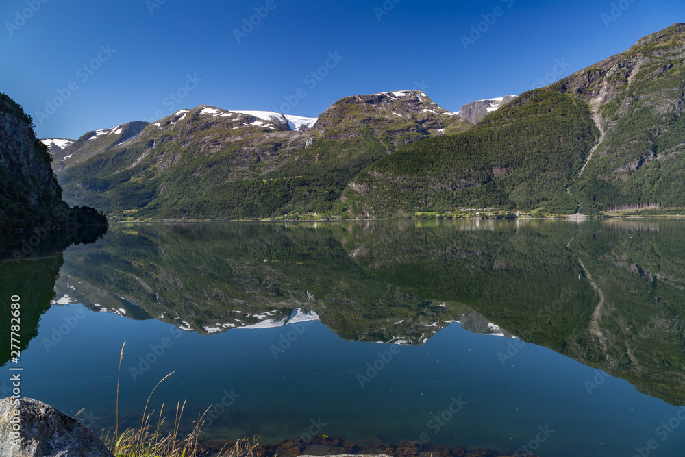 Reflection of the Folgefonna glaciers in the clear, calm waters of Hardangerfjord, Norway