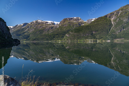 Reflection of the Folgefonna glaciers in the clear, calm waters of Hardangerfjord, Norway
