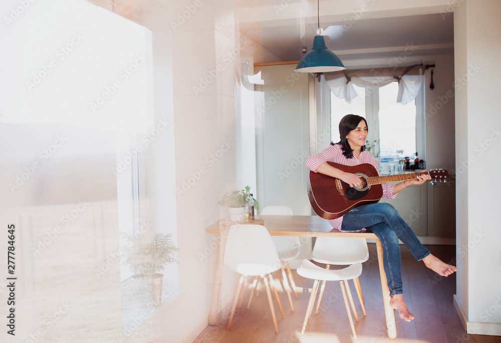 Mature woman playing guitar at home Mature woman playing guitar at home
