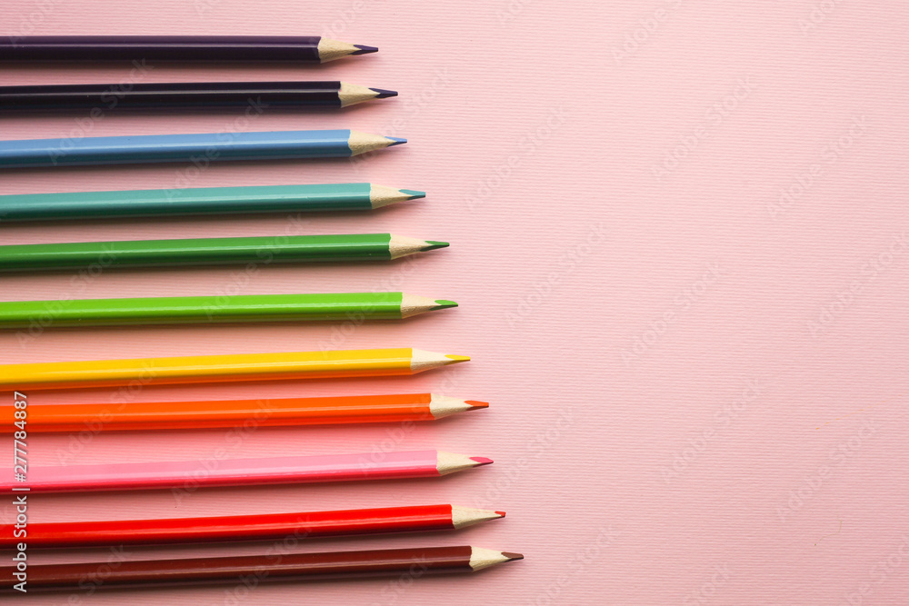 Obraz premium Colorful pencils of rainbow colors on pink pastel background