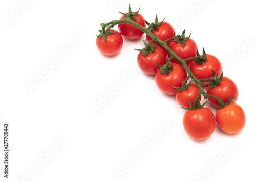 A branch of red cherry tomatoes on a white background. Small and juicy vegetable is rich in vitamins and trace elements. Healthy food. Fresh and organic vegetables. Raw food