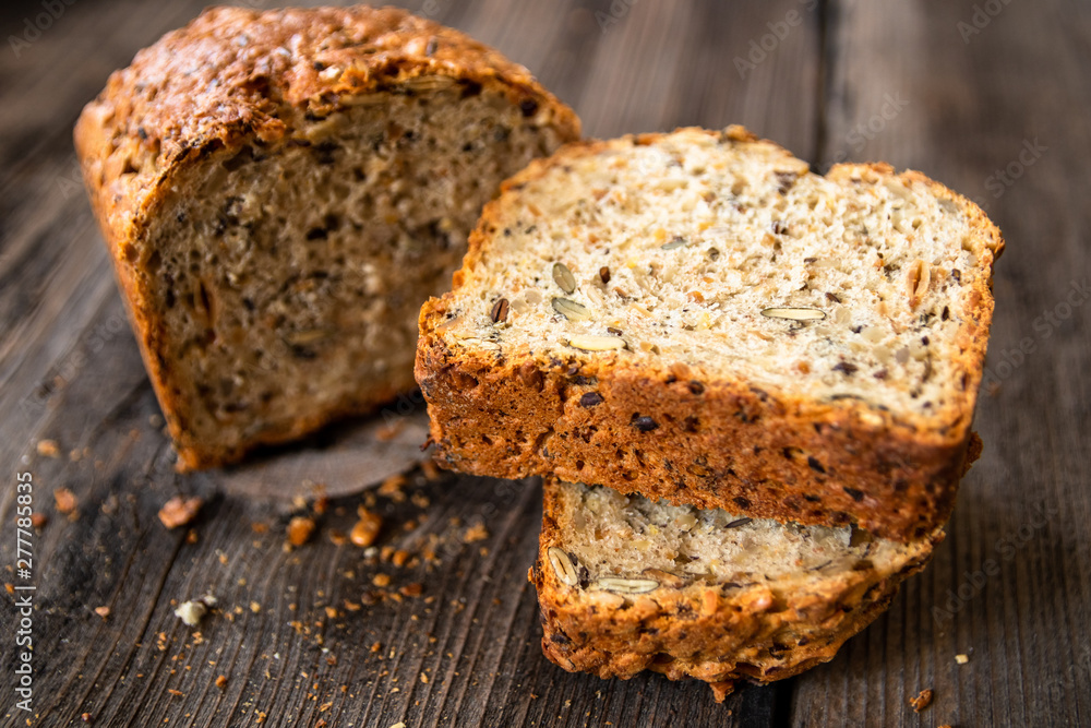 Homemade healthy freshly baked organic whole grain bread with healthy seeds on wooden table Homemade healthy freshly baked organic whole grain bread with healthy seeds on wooden table