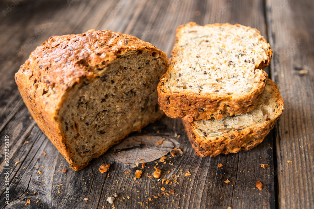Homemade healthy freshly baked organic whole grain bread with healthy seeds on wooden table Homemade healthy freshly baked organic whole grain bread with healthy seeds on wooden table