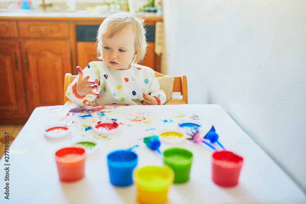 Adorable little girl painting with fingers Adorable little girl painting with fingers