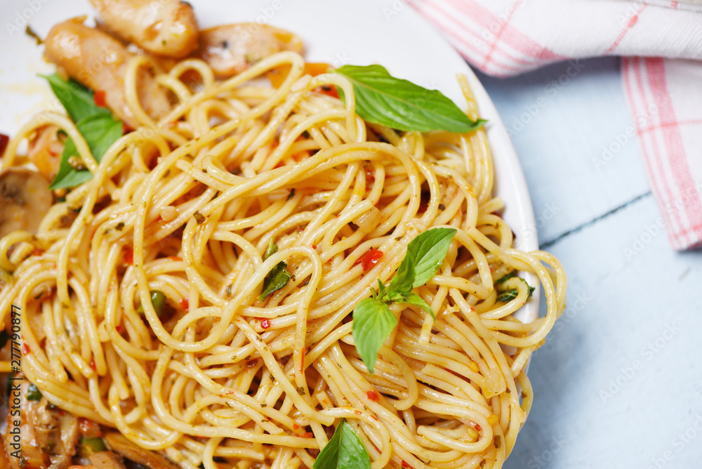 Spaghetti Pasta and tomato chilli and basil leaves vegetables - Traditional delicious Italian food spaghetti bolognese on plate on the dining table Spaghetti Pasta and tomato chilli and basil leaves vegetables - Traditional delicious Italian food spaghetti bolognese on plate on the dining table