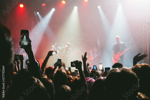 Raised up hands with cellphones recording videos from music show © kondrukhov