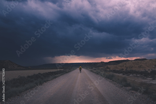 Man standing on road and looking at impressive evening sky