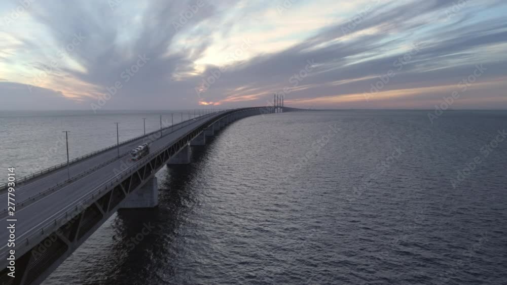 Aerial view of Øresund Bridge at dusk. Drone shot flying over sea and bridge, driving truck and cars at sunset. Connection between Malmö, Sweden and Copenhagen, Denmark Aerial view of Øresund Bridge at dusk. Drone shot flying over sea and bridge, driving truck and cars at sunset. Connection between Malmö, Sweden and Copenhagen, Denmark