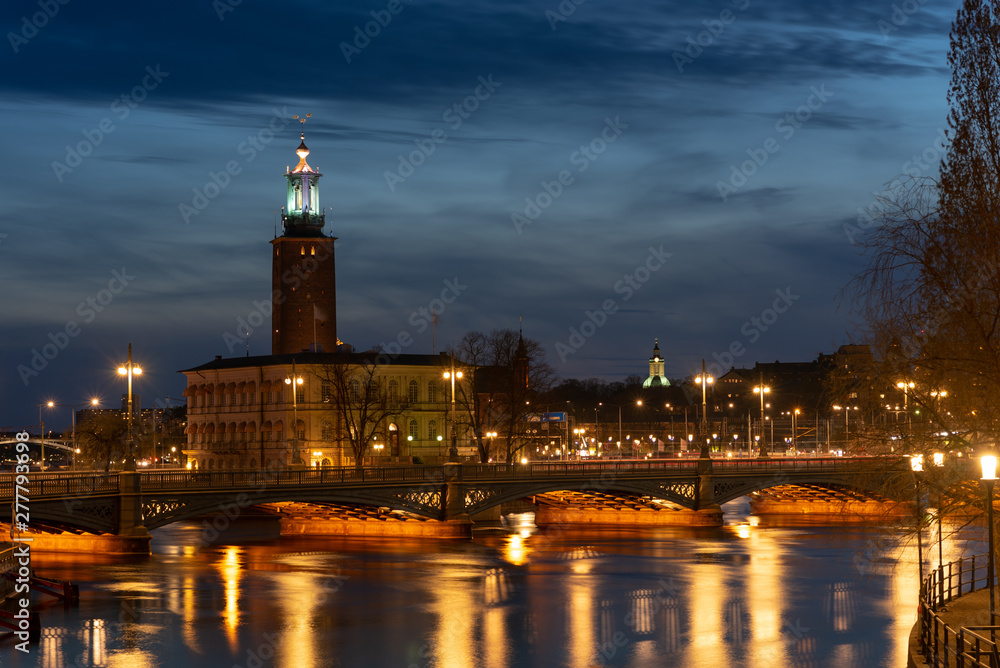 Panoramic view on Stockholm city hall with lights reflection on water