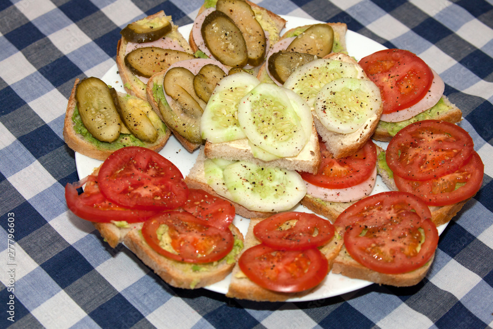 Healthy polish snack sandwiches of sliced tomatoes, pickles and cucumbers sprinkled with pepper. Zawady Poland