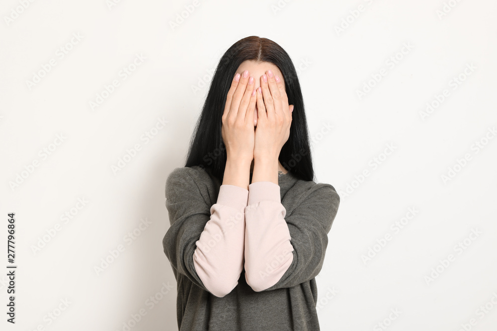 Upset young woman crying against white background Upset young woman crying against white background
