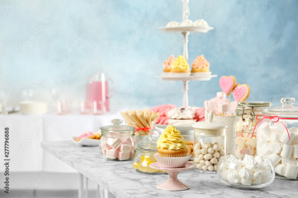 Candy bar with different sweets on white marble table indoors. Space for text