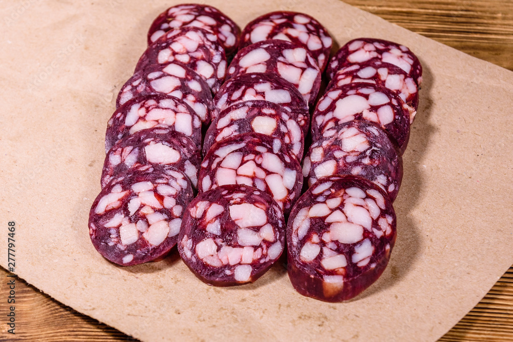 Sliced salami sausage on a brown wrapping paper Sliced salami sausage on a brown wrapping paper