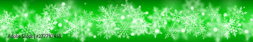 Christmas banner of complex blurred and clear snowflakes in white colors on green background. With horizontal repetition