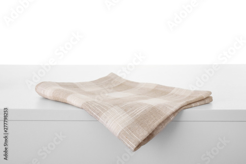 Folded kitchen towel on light table against white background