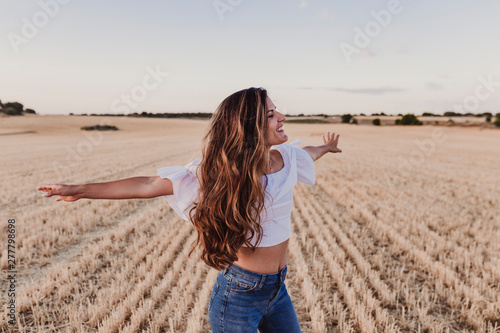 Fotografie Summer Girl enjoying nature on yellow field
