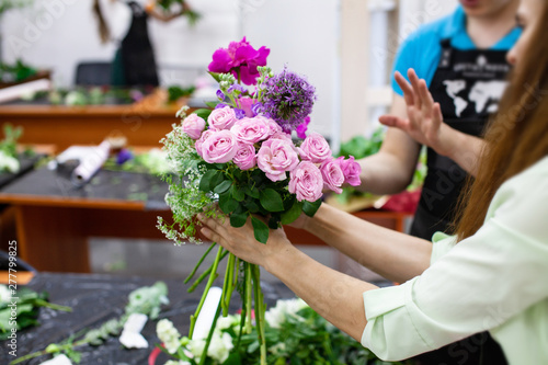 Female florist create a bouquet at workplace. Floristics workshop. Making beautiful flower bouquets and floral decorations..