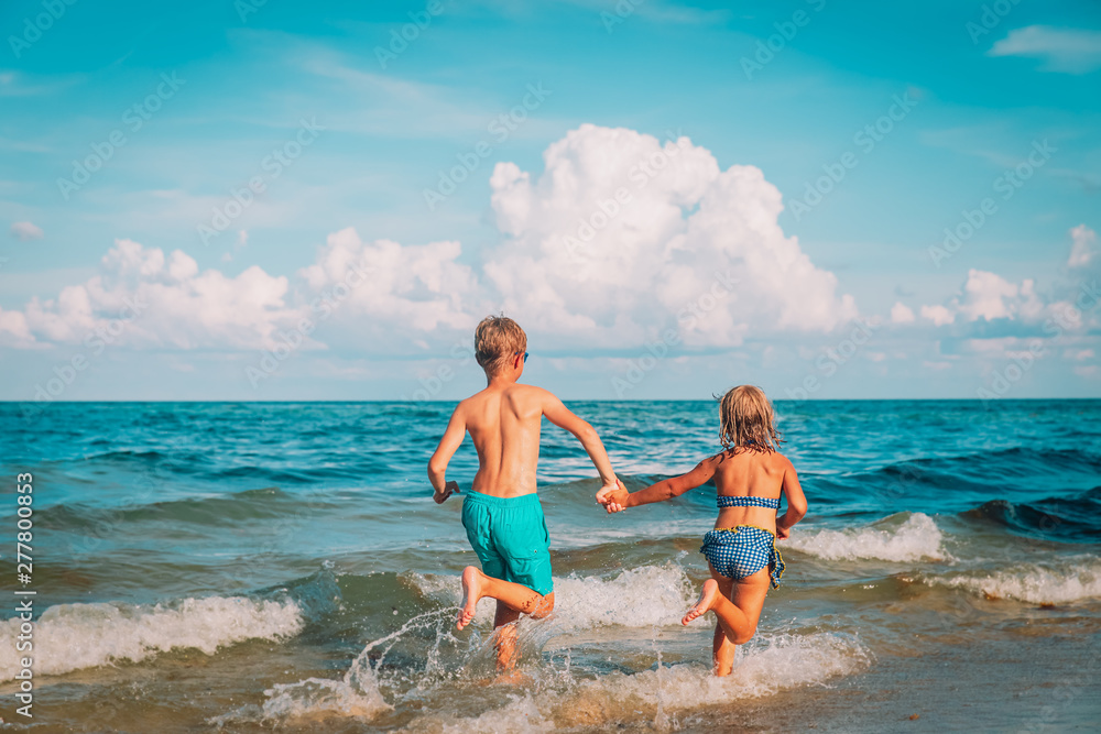 Obraz premium happy boy and girl run play at beach