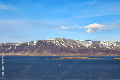 Landscape with mountains, sea and white sailboat