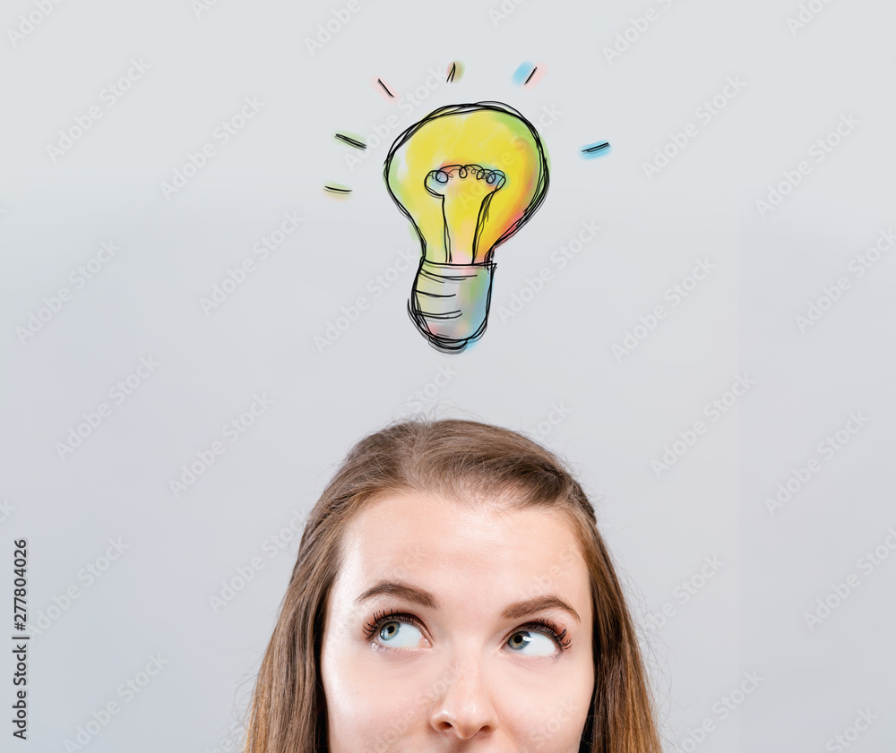 One light bulb with young woman looking upwards One light bulb with young woman looking upwards