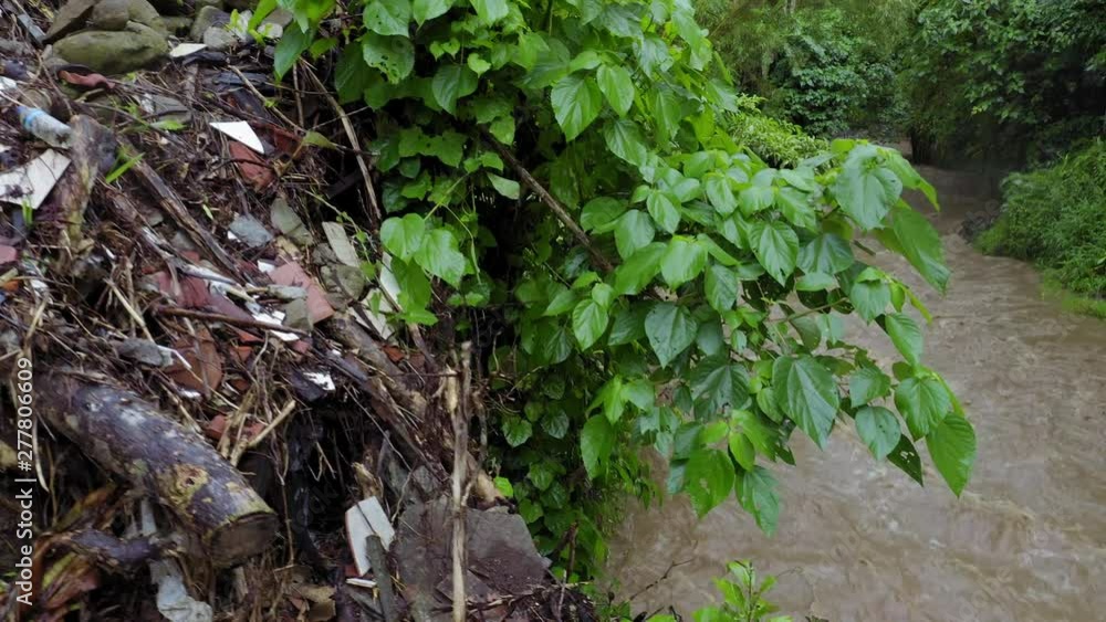 Aerial: Rubbish such as plastic water bottles and wrappers piled up in a river in Ubud, Bali. Aerial: Rubbish such as plastic water bottles and wrappers piled up in a river in Ubud, Bali.