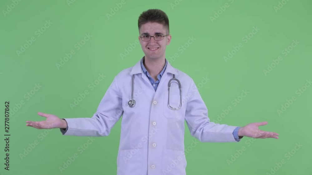 Happy young man doctor comparing something Happy young man doctor comparing something