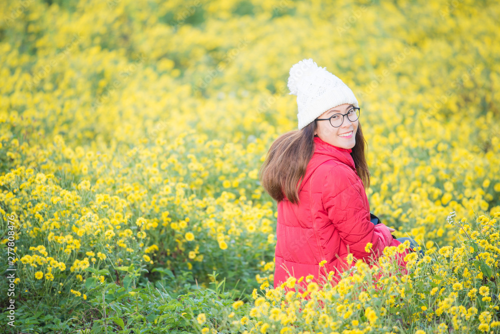 Fototapeta premium Portrait of Asian woman enjoying her holiday in Chrysanthemum flowers field on Doi Sango mountain in Chiang Saen district of Chiang Rai province, Thailand.