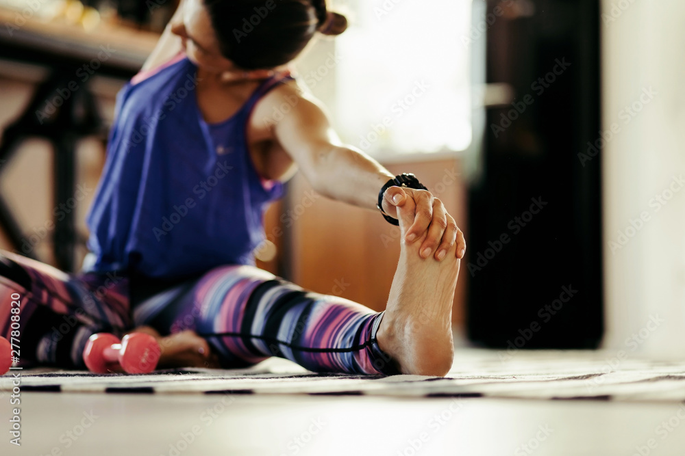 Close-up of athletic woman stretching on the floor. Close-up of athletic woman stretching on the floor.
