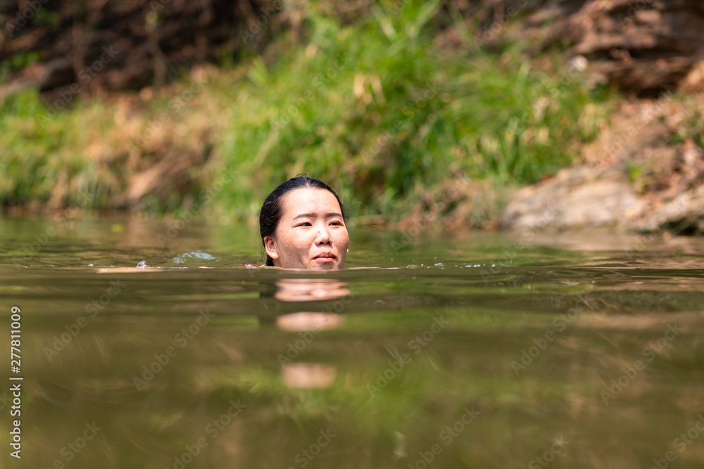 Fototapeta premium Asian woman swimming in river