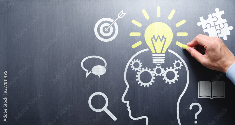 © tadamichi - Knowledge and inspiration. Drawing lightbulb and head silhouette on chalkboard.