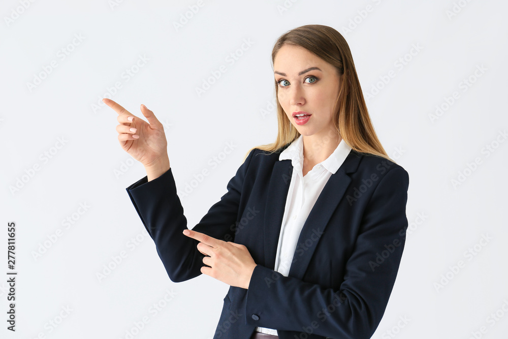 Beautiful young businesswoman pointing at something on white background Beautiful young businesswoman pointing at something on white background