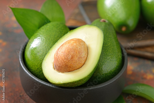 Bowl with fresh ripe avocados on table