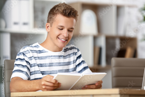 Male student reading book w...