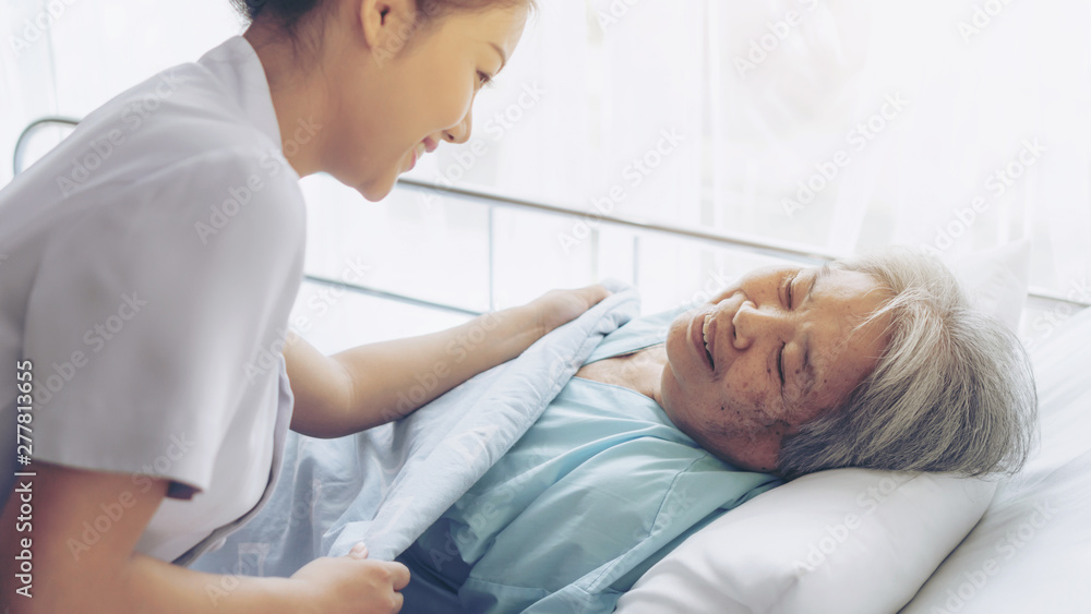 the nurses are well good taken care of elderly patients in hospital bed patients feel happyness - medical and healthcare concept the nurses are well good taken care of elderly patients in hospital bed patients feel happyness - medical and healthcare concept