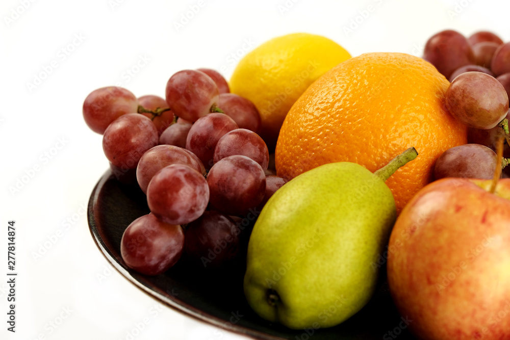 A heap of different tropical fruits isolated on Ceramic plate. Healthy and organic fair concept. - Image A heap of different tropical fruits isolated on Ceramic plate. Healthy and organic fair concept. - Image