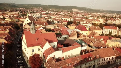 Aerial drone view of Piata Mare, the largest square in Sibiu city, in Romania. A city in Transylvania during sunset time in Europe.
