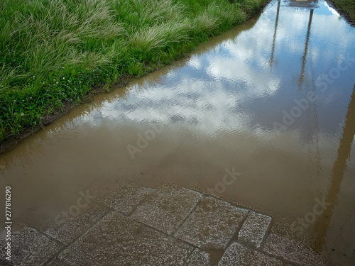 畦道の水溜りに映る空と雲