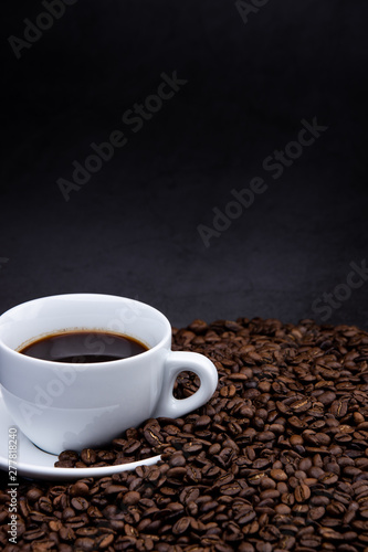 cup of coffee with beans on wooden background