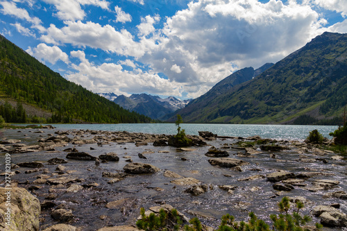 Multinsky lakes in Altai mountains. Picturesque landscape with huge stoune, clouds and blue water.