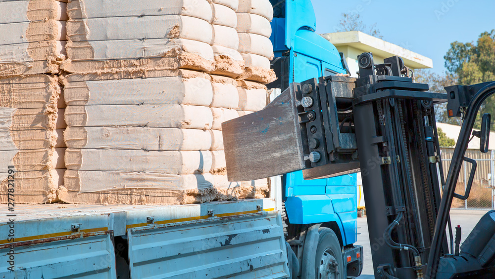 Forklift loading the bales of coton in a truck (TIR) - Cotton bales, ready for delivery to cotton buyers. Forklift loading the bales of coton in a truck (TIR) - Cotton bales, ready for delivery to cotton buyers.