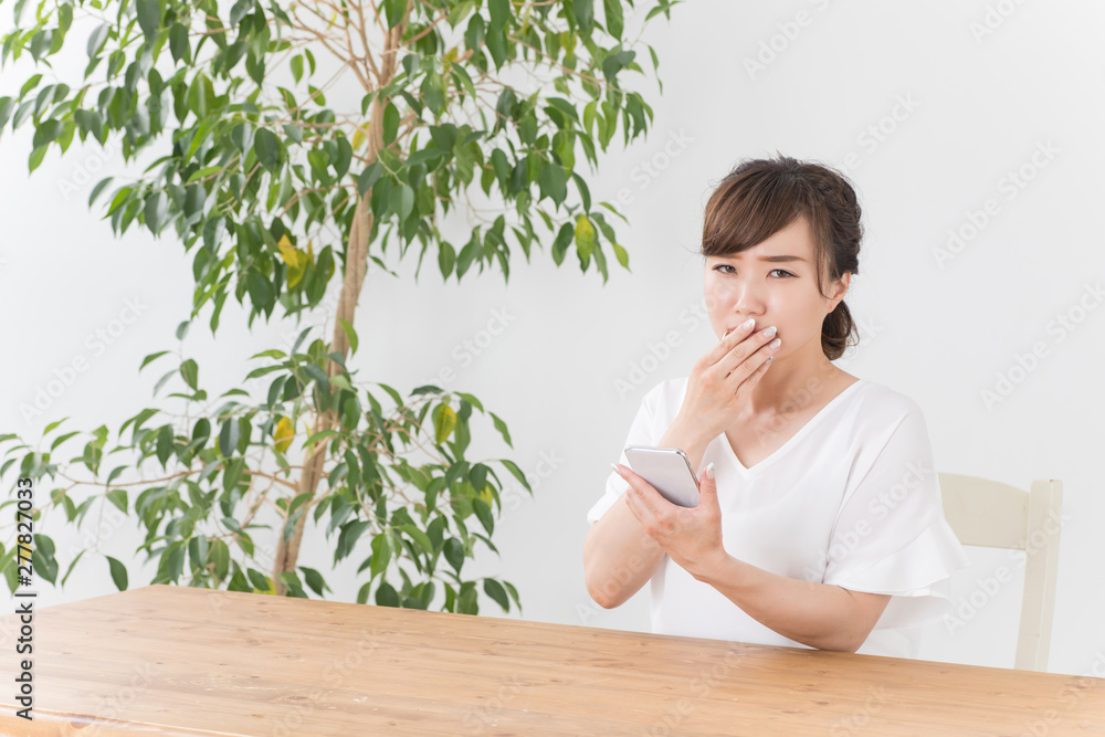 スマホを見て困る女性 スマホを見て困る女性