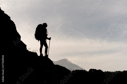 Silhouette of female hiker posing on mountain
